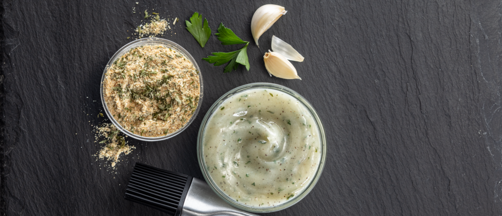 Garlic seasoning and dipping sauce on a slate background