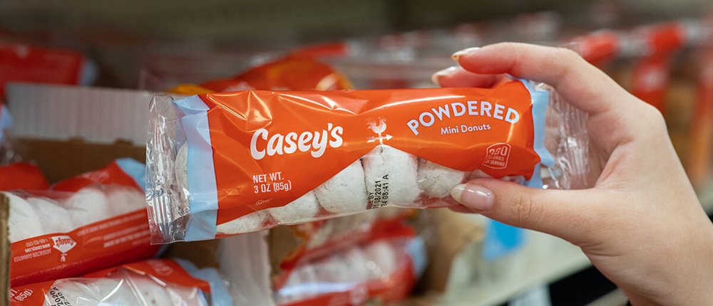 Someone holding a pack of Casey's powdered mini donuts