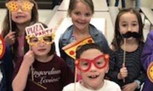 Elementary school kids having fun with pizza cutouts and costumes