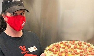 Casey's team member with a pizza